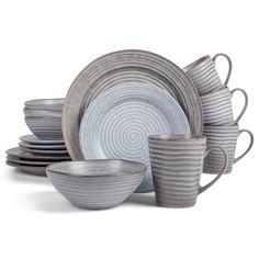 a stack of dishes with cups and saucers on top of each other, all in grey