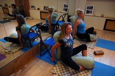 a group of women sitting on yoga mats in a room