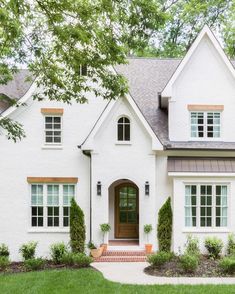 a white house with green grass and trees