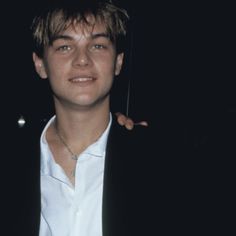 a young man wearing a white shirt and black blazer