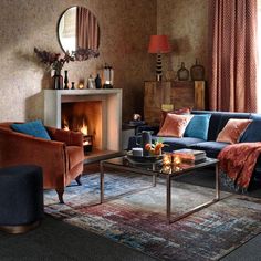 a living room filled with furniture and a fire place under a mirror on the wall