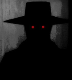 a man with red eyes wearing a black hat