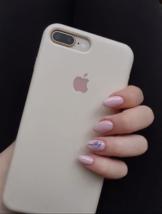 a woman's hand holding an iphone case with pink and white nail polish on it