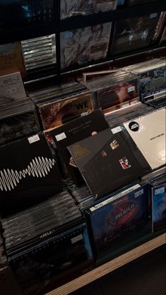 many cds are stacked on top of each other in a store display case with sound waves coming out of them