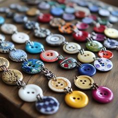 many different colored buttons on a wooden surface