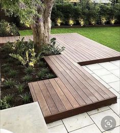 a wooden deck in the middle of a garden