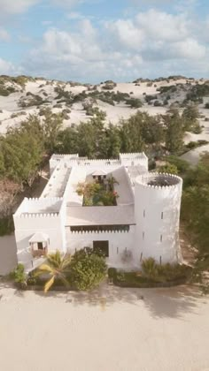 an aerial view of a house in the middle of sand dunes with trees and bushes