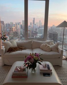 a living room filled with furniture and a large window covered in cityscape behind it