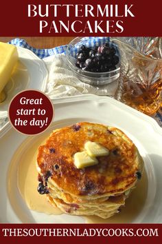 a stack of pancakes with butter and blueberries on top, sitting on a plate