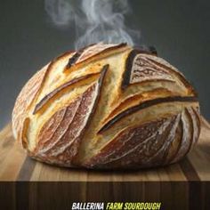 a loaf of bread sitting on top of a wooden table with steam rising out of it