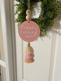 a pink door hanger with the words probably running late hanging from it's side