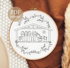 a cross - stitch pattern with a nativity scene in the hoop on top of a blanket