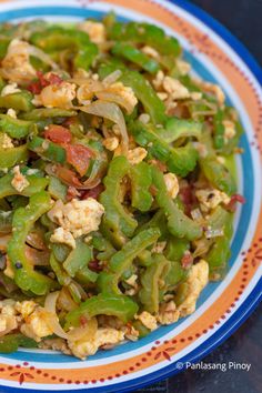 a colorful plate filled with green beans and other food items on top of a table