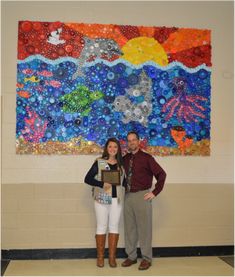 a man and woman standing in front of a painting