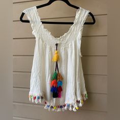 Size Xl Love J Brand New Bohemian Style Too Sleeve Can Be Styled In Multiple Ways, Off The Shoulder Or Sleeveless Top Colorful Big Tassel In The Middle And Lower Rim With Colorful Details Sleeveless Fringe Top For Beach Season, White Cotton Top With Back Tassel Tie-up, White Cotton Tops With Back Tassel Tie-up, Casual Summer Tops With Back Tassel Tie-up, Casual Beach Tops With Tassels, Casual Festival Tops With Tassels, Casual Tops With Tassels For Festival, Multicolor Bohemian Tops With Tassels, Multicolor Bohemian Top With Tassels