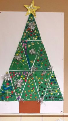 a christmas tree made out of construction paper on a white board with gold star above it