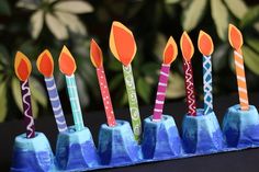 there are many birthday candles in the blue vases