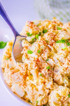 a white bowl filled with potato salad on top of a table