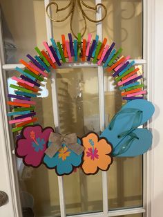 a wreath made out of flip flops and flowers on a front door hanger