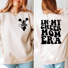 In My Cheer Mom Era Sweatshirt, Custom Cheer Mama Sweatshirt, Cheer Mom Gift, Your Kids Name,Football Mom Sweatshirt, Funny Cheerleading Mom   PRODUCT DETAILS - Our sweatshirts are made for comfort with a 50% cotton and 50% polyester blend. - They're built to last with a medium-heavy fabric (8.0 oz/yd²). - Enjoy a relaxed fit and a sewn-in label. - Get the right size with our true-to-size guide.   SIZING - Find your perfect fit in our size chart with pictures. - For oversize look, you might cons School Spirit Long Sleeve Tops For Football Season, Varsity White Tops For Cheerleading, White Varsity Tops For Cheerleading, Team Spirit Long Sleeve Top With Lettering, Fall Cheerleading Top With Letter Print, Long Sleeve T-shirt With Lettering For Sports Events, Long Sleeve Football Team Tops, White Long Sleeve Sports Fan Sweatshirt, Collegiate Long Sleeve Sweatshirt For Cheerleading