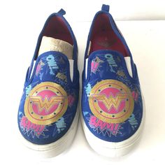 a pair of shoes with wonder women's logo painted on the front and side