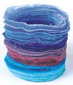 a stack of blue, purple, and red paper stacked on top of each other