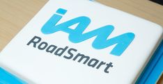 a white and blue square with the word roadsmart on it's side sitting on top of a wooden table