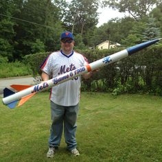 a man in a baseball uniform is holding a rocket