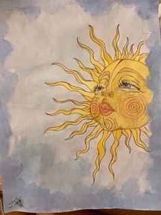 a drawing of a sun on a piece of paper with blue sky and clouds in the background