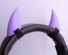 two horns are attached to the back of a pair of headphones with purple ears