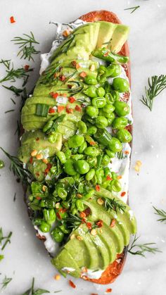 an open faced sandwich with peas, avocado and sprouts on it