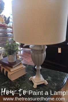 a lamp sitting on top of a table next to books and a potted plant