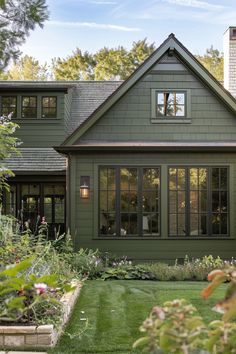 a green house with lots of windows in the front yard