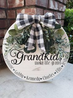 a wooden sign that says grandkids make life great and is hanging on the side of a brick wall