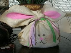 a bunny bag sitting on top of a table next to a plant in a pot