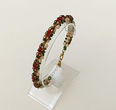 a beaded bracelet with glass beads on a clear acrylic display stand against a white background