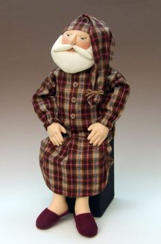 an old man with a beard sitting on top of a box wearing a plaid coat