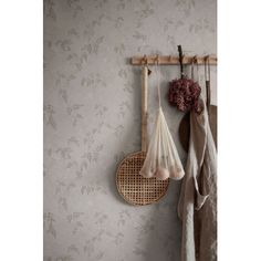 two rackets hanging on the wall next to a towel rack with flowers and towels