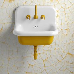 a white sink sitting next to a yellow wall