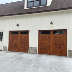 two brown garage doors in front of a white building