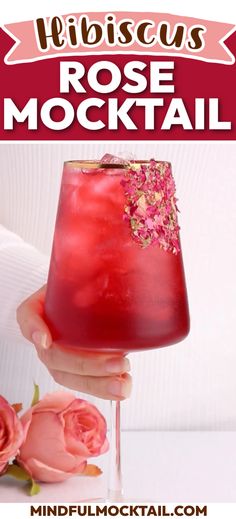 a hand holding a drink with pink flowers around it and the words, fibrocuss rose cocktail