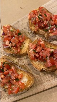 four pieces of bread with tomatoes and herbs on them