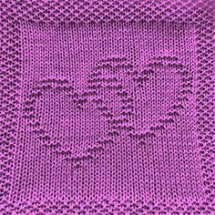 a pink knitted blanket with the word love written on it