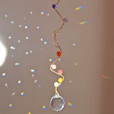 a multicolored necklace hanging from a gold chain