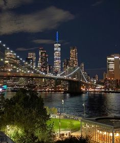 the city skyline is lit up at night, and it's lights shine brightly