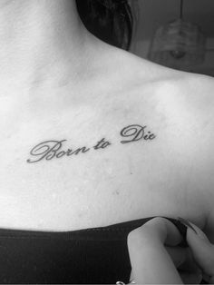 a woman's chest with the words born to die tattooed on her left shoulder