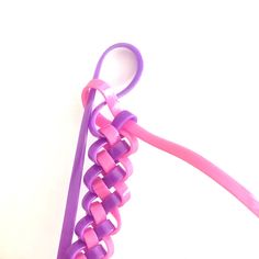 two pink and purple hair clips sitting next to each other on a white table top