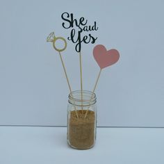 there is a small jar with some sand in it and two hearts on the top