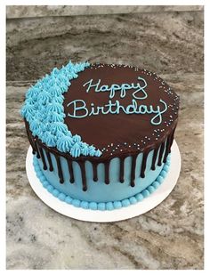 a chocolate birthday cake with blue frosting and sprinkles on the top