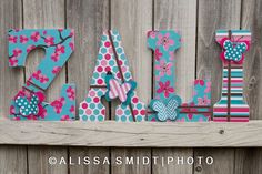 the word love is made out of wood and decorated with pink, blue and white polka dots